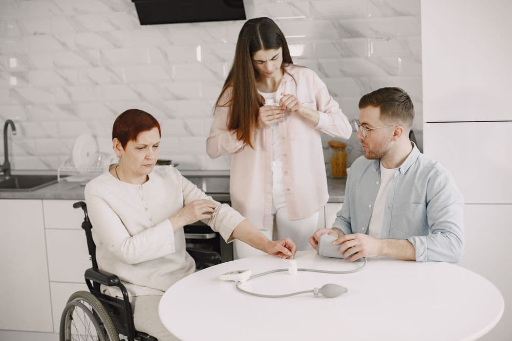 A family sitting around a kitchen table with a relative who uses a wheelchair